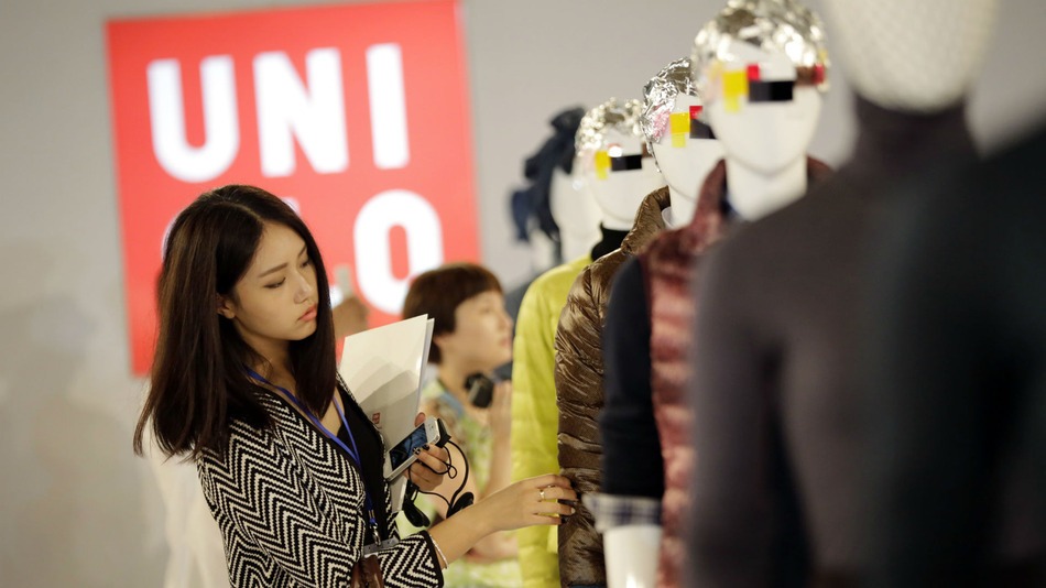 A journalist looks at the latest collection of Uniqlo brands during a press conference in Shanghai China Eugene Hoshiko Associated Press