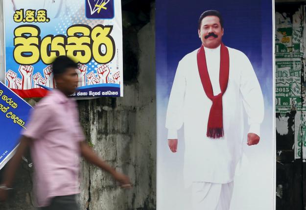 A man walks past a poster of Sri Lanka's former president Mahinda Rajapaksa in Galle