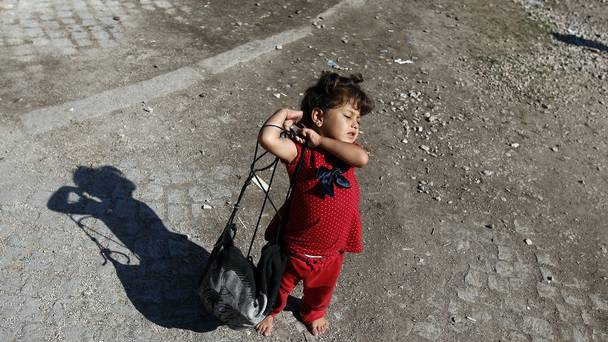 A migrant girl carries her bag at a migrant processing centre in the southern Serbian town of Presevo