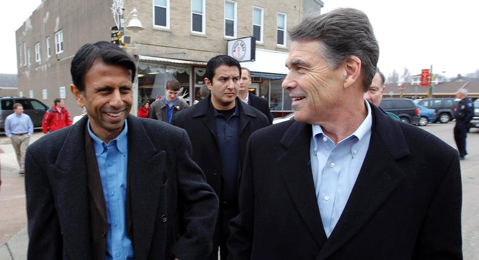 Republican presidential candidate Texas Gov. Rick Perry right walks with Louisiana Gov. Bobby Jindal during a campaign stop in De Witt Iowa Tuesday Dec. 20 2011