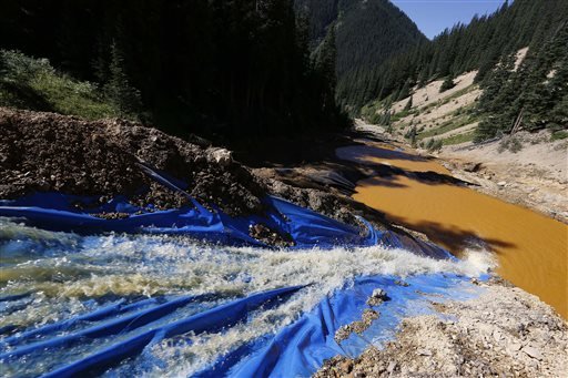 Water flows through a series of sediment retention ponds built to reduce heavy metal and chemical contaminants from the Gold King Mine wastewater accident in the spillway about 1/4 mile downstream from the mine outside Silverton Colo. Friday Aug. 14