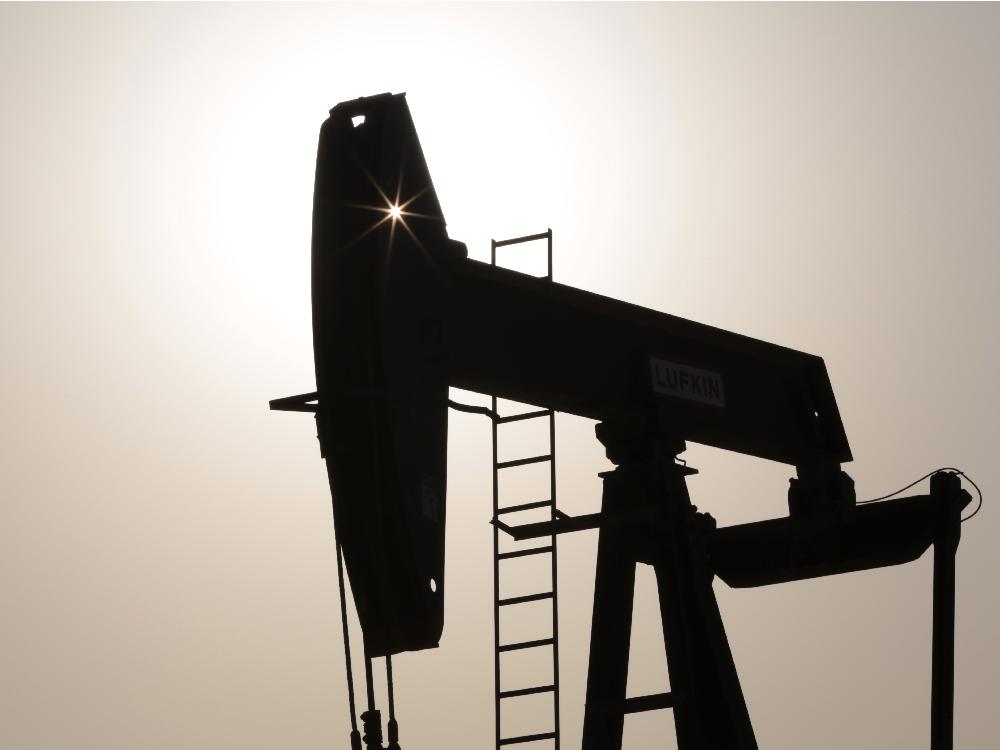 An oil pump works at sunset Thursday in the desert oil fields of Sakhir Bahrain