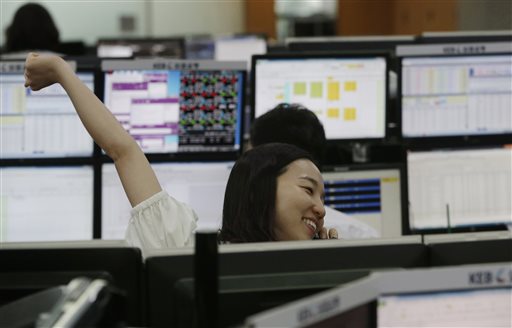 A currency trader stretches while working at the foreign exchange dealing room of the Korea Exchange Bank headquarters in Seoul South Korea Thursday Aug. 27 2015. Asian stocks rose Thursday after Wall Street soared overnight breaking a six-day string