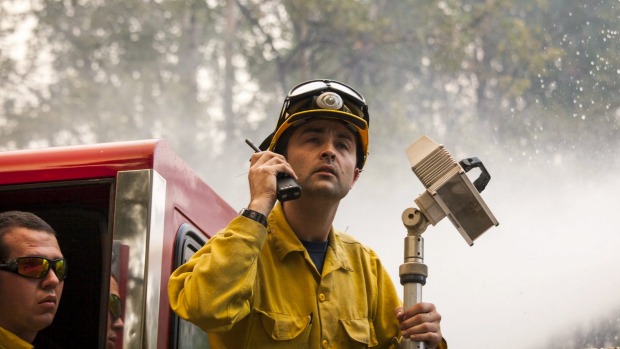 Firefighters stand on a fire engine while battling the Twisp River fire in Washington state Resources are so stretch one fire chief was unable to get any backup