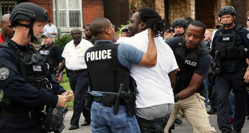 Police arrest a protester that was in the middle of the street after a shooting incident in St Louis Missouri on Aug 19