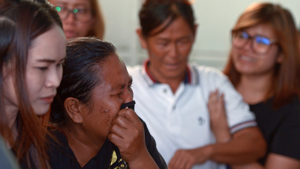 Relatives of a Thai man killed in a bomb blast outside a religious shrine grieve after identifying the body at the Institute of Forensic Medicine in Bangkok