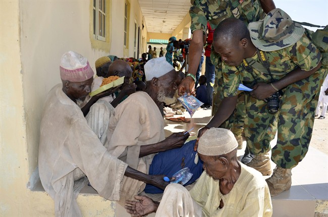 Men and children rescued by Nigerian soldiers from Boko Haram extremists in northeast Nigeria eat a meal on their arrival at the military office in Maiduguri Nigeria Thursday