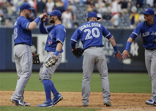 Toronto Blue Jays first baseman Justin Smoak left high-fives Kevin Pillar as Josh Donaldson greets Troy Tulowitzki after they defeated the New York Yankees 6-0 in a baseball game Saturday Aug. 8 2015 in New York