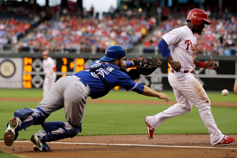 Philadelphia Phillies Odubel Herrera right scores past Toronto Blue Jays catcher Russell Martin on an RBI-single by Darin Ruf during the first inning of a baseball game Wednesday Aug. 19 2015 in Philadelphia. Ruf advanced to third base on the throw