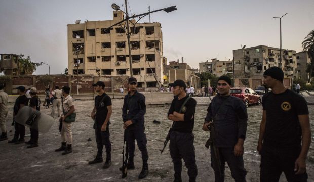 Egyptian riot policemen stand in front of the damaged national security building in northern Cairo's district of Shubra Al Kheima