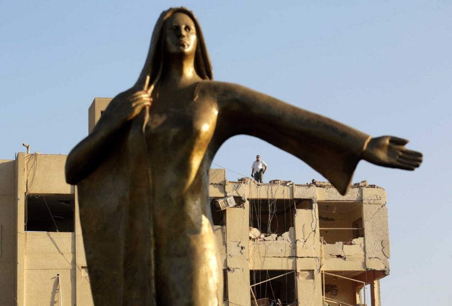 An Egyptian plainclothes policeman stands on the top of the damaged national security building after a bomb exploded early Thursday Aug. 20 2015 in the Shubra el Kheima neighborhood of Cairo injuring several people Egyptian security officials said. T