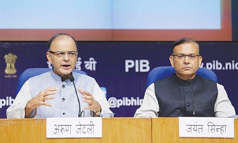 Indian Finance Minister Arun Jaitley gestures as Junior Finance Minister Jayant Sinha watches during a news conference in New Delhi on India needs to minimise political interference in public sector banks Jaitley said on, as the gov