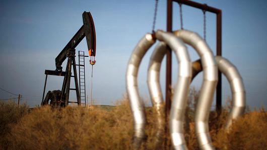 A pump jack and pipes at an oil field near Bakersfield California