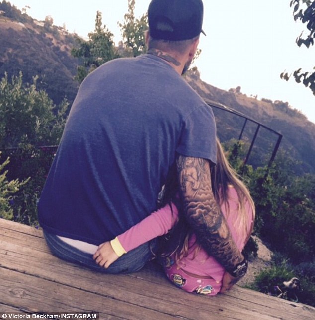 Daddy's girl David Beckham lovingly cradled his four-year-old daughter Harper as the pair admired a hilltop view in Los Angeles California in this sweet shot posted on Victoria's Instagram account on Monday