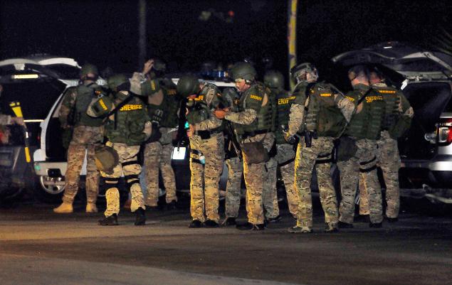 Craig Rubadoux FLORIDA TODAY                    Brevard County Sheriff's officers gather at the scene after shots were fired night in Port St John Fla