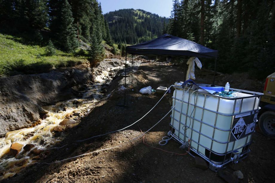 A plastic container feeds additives through tubes into mine wastewater flowing into a series of sediment retention ponds part of danger mitigation in the aftermath of the blowout at the site of the Gold King Mine outside Silverton Colo. Friday Aug. 1