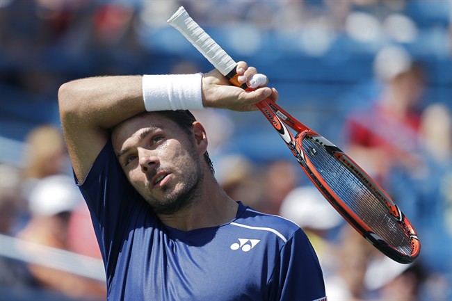 Stanislas Wawrinka of Switzerland wipes sweat from his forehead during a quarterfinal match against Novak Djokovic of Serbia at the Western & Southern Open tennis tournament