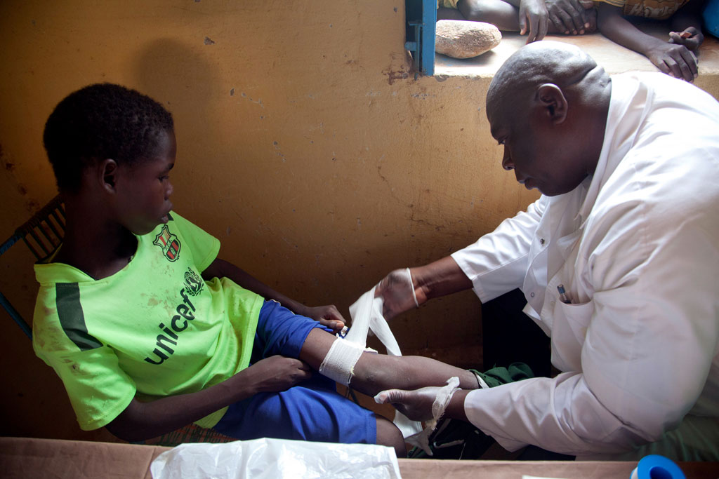 A young boy in the Kassab Camp for internally displaced persons in North Darfur is assisted by a doctor after being bitten by a dog. UN