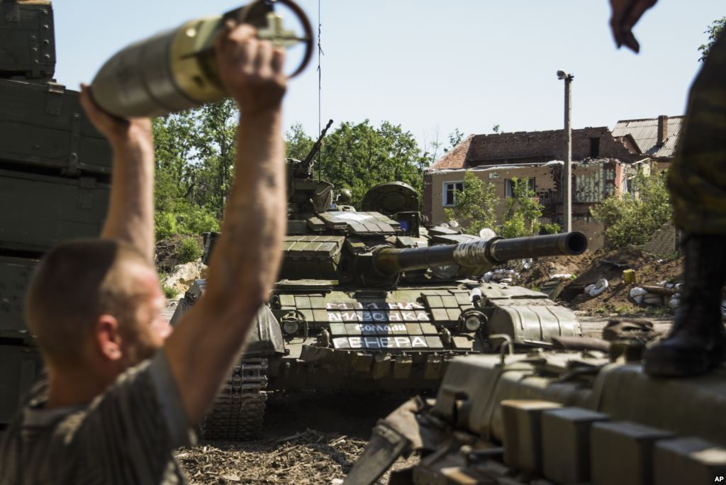 FILE- A pro Russia rebel loads shells onto a tank near Donetsk eastern Ukraine