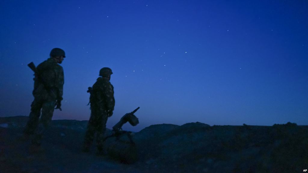 FILE- Russia-backed rebels are seen guarding territory after sunset near Donetsk eastern Ukraine Aug. 2 2015