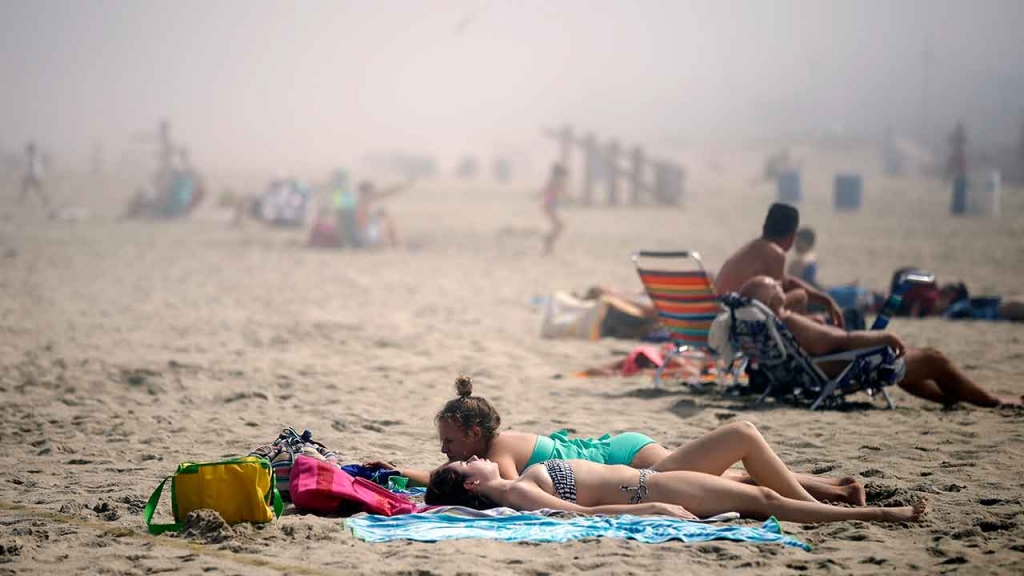 FILE Sunbathers lay on the beach on a foggy afternoon in Belmar N.J