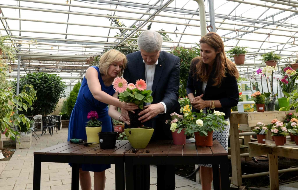 Conservative Leader Stephen Harper and his wife Laureen plant a flower with Conservative candidate Pascale Dery in Drummondville Que. Monday