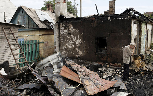 A man cries as he inspects debris while standing outside his damaged house which according to locals was caused by recent shelling in Donetsk