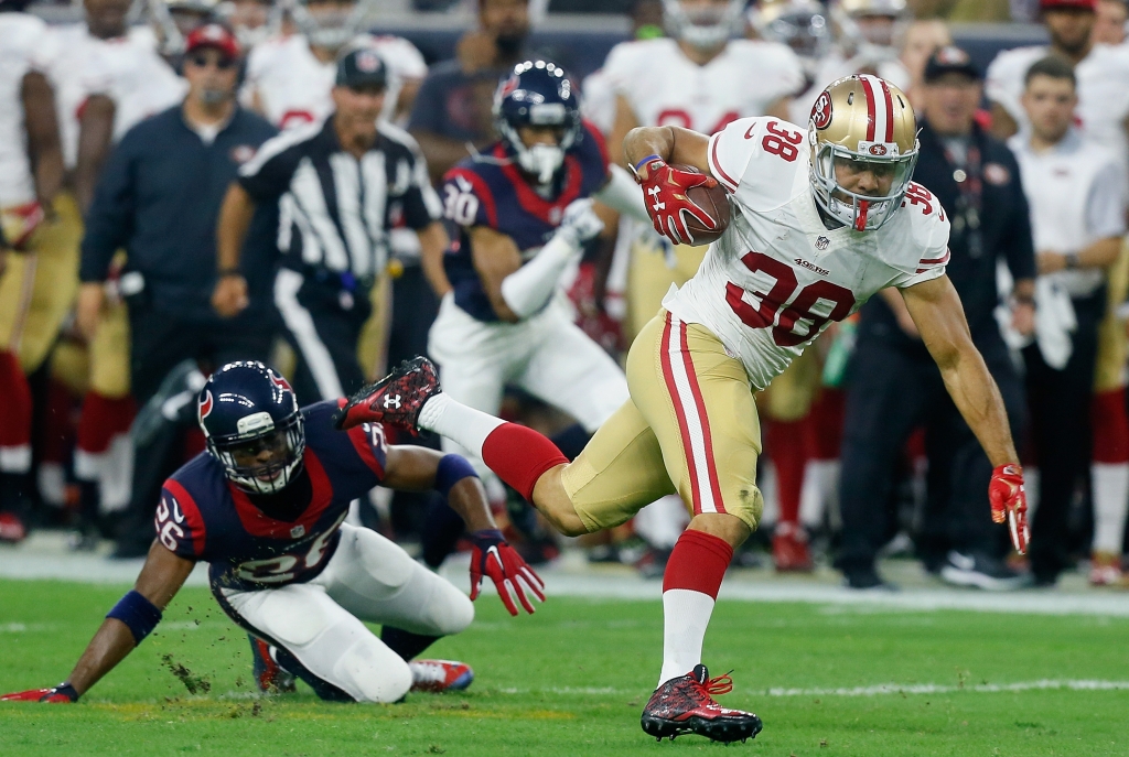 HOUSTON TX- AUGUST 15 Jarryd Hayne #38 of the San Francisco 49ers breaks the tackle attempt of Rahim Moore #26 of the Houston Texans in the first half at Reliant Arena at Reliant Park