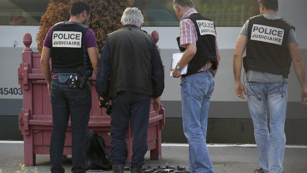 French judicial police stand on the train platform near gun cartridges and a backpack in Arras France