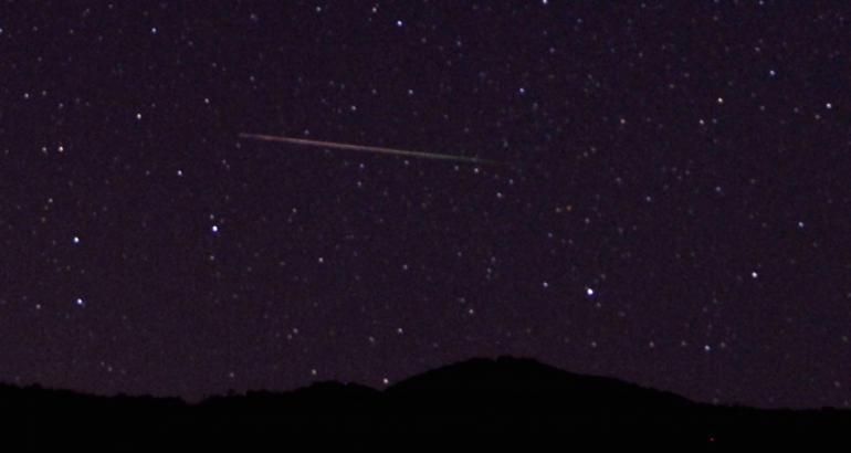 A meteor streaks over the northern skies in the early morning during the Perseid meteor shower north of Castaic Lake California