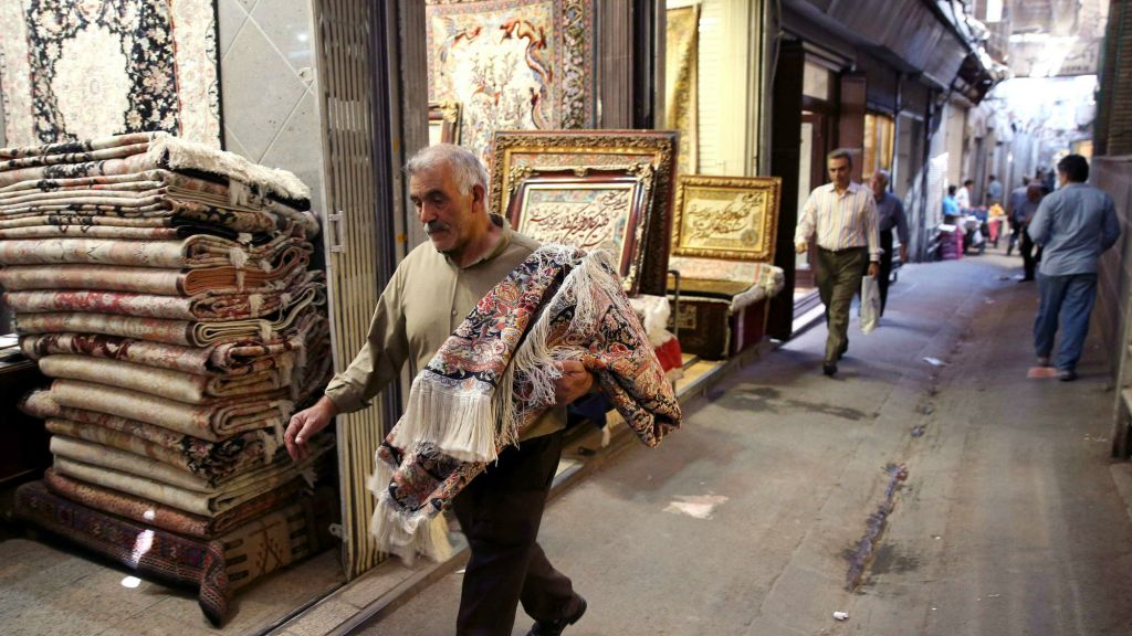 Iranian man carries a carpet through Tehran's old main bazaar Iran