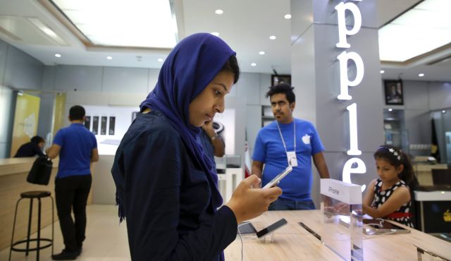 Iranian woman tries out an iPhone at shop selling Apple products in Tehran. Aug. 5 2015