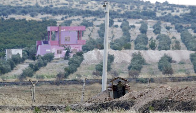 A Turkish soldier stands guard at the Turkish Syrian border in Karkamis