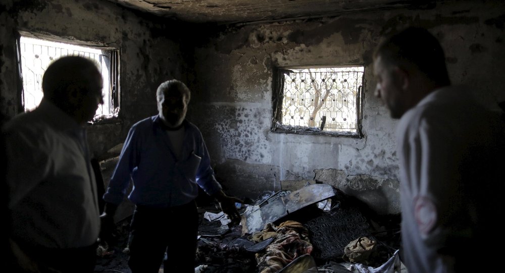 Palestinians inspect a house which was set on fire in a suspected attack by Jewish extremists in Duma village near the West Bank city of Nablus