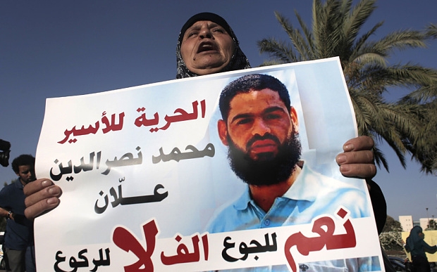 Maazouze the mother of Mohammed Allaan holds a portrait of her son during a rally calling for his release in the southern Israeli city of Beersheva