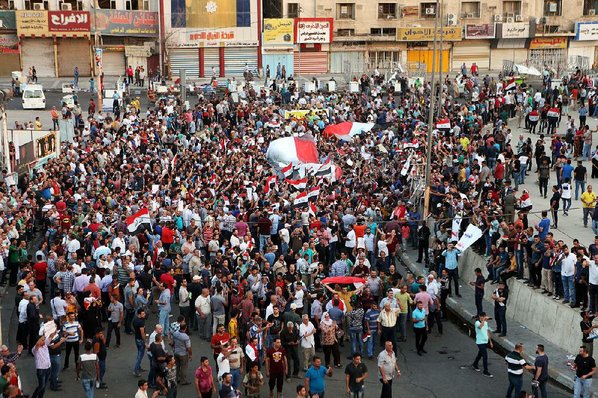 KHALID MOHAMMED						Credit AP				Iraqis wave national flags during a demonstration Sunday at Tahrir Square in Baghdad