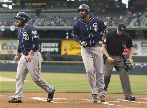 San Diego Padres Matt Kemp center crosses home plate after hitting a two-run home run to drive in teammate Derek Norris left as home plate umpire Lance Barrett cleans off the plate against the Colorado Rockies in the first inning of a baseball game F