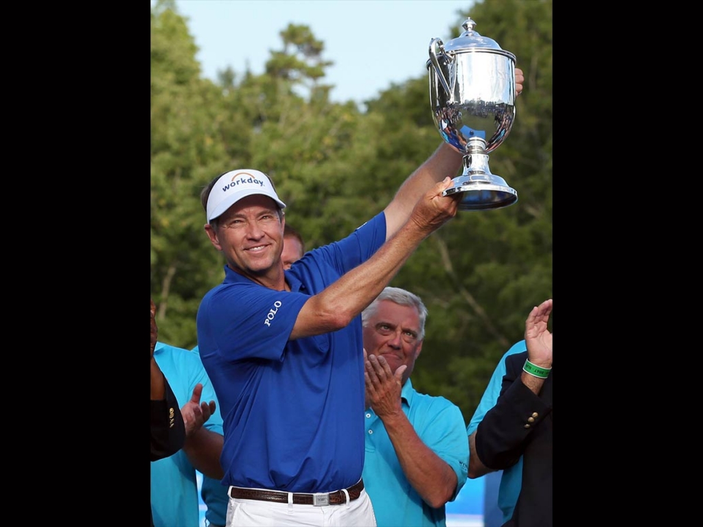 Davis Love III raises the trophy after winning the Wyndham Championship golf tournament at Sedgefield Country Club in Greensboro N.C