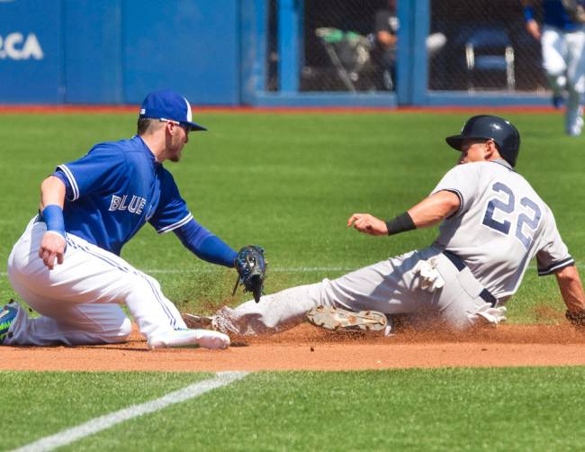 New York Yankees&#39 Jacoby Ellsbury is tagged out trying to steal second base by Toronto Blue Jays third baseman Josh Donaldson during first inning baseball action in Toronto Sunday Aug. 16 2015