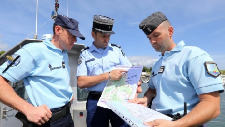 AFP  File | French maritime gendarmes look at a map indicating measures being undertaken in the search for wreckage from the missing MH370 plane at the marina of Saint Marie on the French island of La Reunion