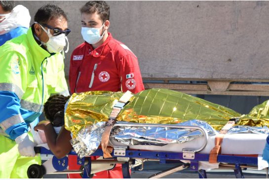 A migrant is carried on a stretcher after disembarking from the Irish Navy vessel LE Niamh in Sicily Italy Aug. 24 2015. Italy's coast guard said Wednesday about 50 people have been found dead on another migrant boat