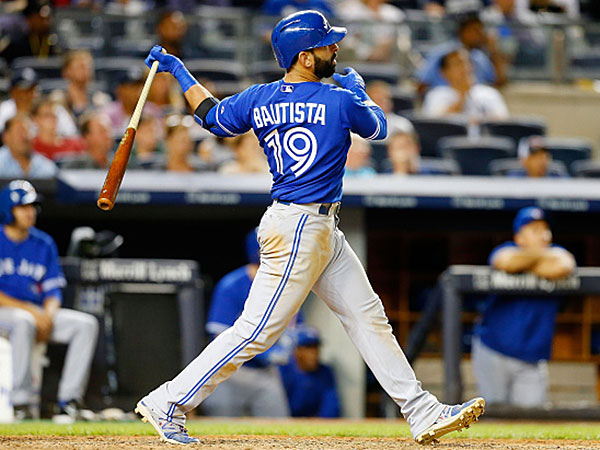 Jose Bautista #19 of the Toronto Blue Jays follows through on his tenth inning home run against the New York Yankees at Yankee Stadium