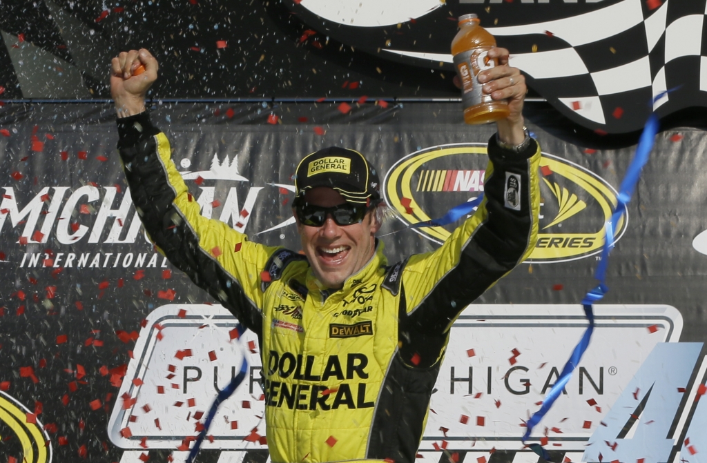 Matt Kenseth raises his arms in victory lane after winning the NASCAR Sprint Cup series auto race at Michigan International Speedway Sunday Aug. 16 2015 in Brooklyn Mich