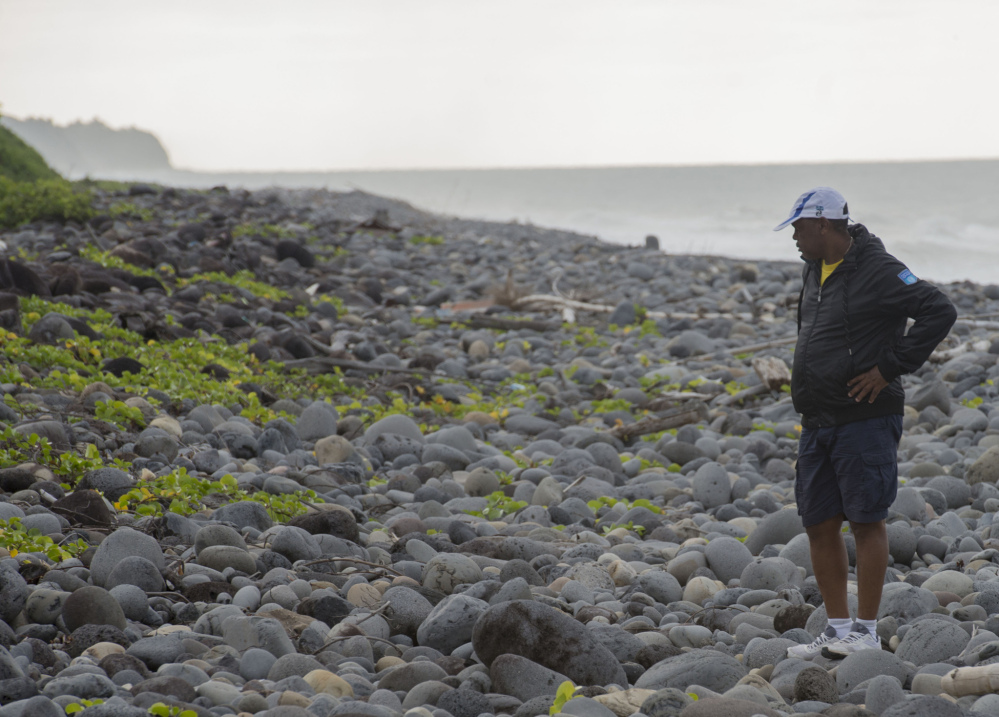 An unidentified man walks on Reunion’s Saint Andre beach as the search for more debris from the missing Malaysian Airlines Flight 370 continues Thursday