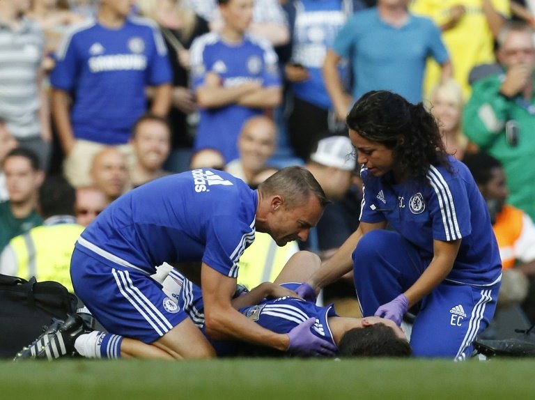 Chelsea doctor Eva Carneiro and head physio Jon Fearn treat Chelsea's Belgian midfielder Eden Hazard during the English Premier League football match between Chelsea and Swansea City at Stamford Bridge in London