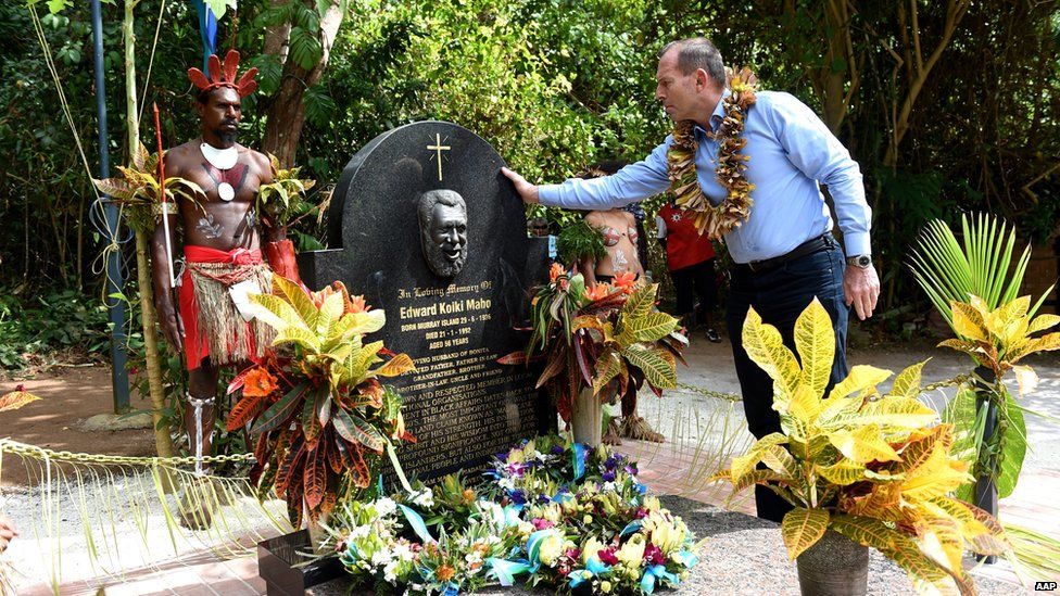 Mr Abbott places his hand on the headstone of Eddie Mabo