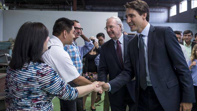 Former prime minister Paul Martin centre and Liberal Leader Justin Trudeau right greet employees at a small manufacturer on Tuesday in Toronto