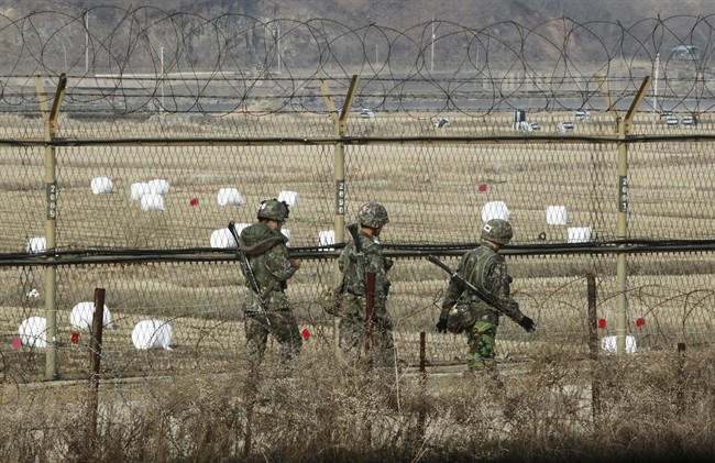 South Korean army soldiers patrol along a barbed-wire fence near the border village of Panmunjom in Paju South Korea Monday