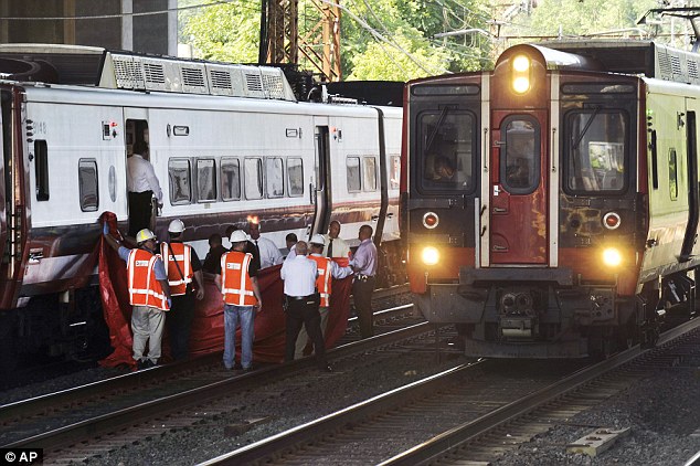 Metro Transit Authority personnel investigate the scene where a 28-year-old woman who was trying to retrieve a wallet or handbag from the tracks was struck and killed by a commuter train on Friday morning near the Cos Cob train station in Greenwich Con