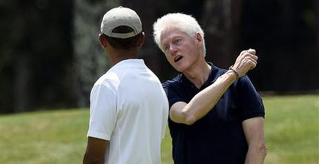 President Barack Obama left talks with former President Bill Clinton center as they play golf on the first hole at Farm Neck Golf Club in Oak Bluffs Mass. on Martha's Vineyard Saturday Aug. 15 2015. AP